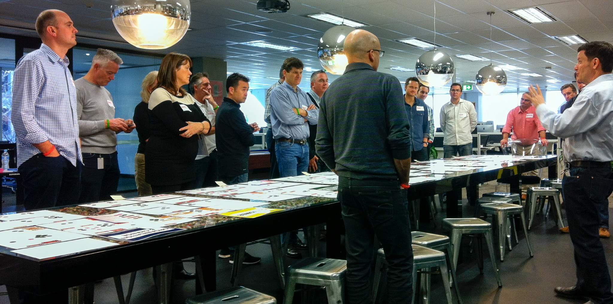 James facilitating a room-wide leadership discussion around a large visible enterprise framework